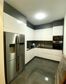 Moderna ugaona kuhinja Svetix - farbani medijapan u beloj boji u kombinaciji sa univerom Kaindl - kaljeno staklo u crnoj boji umesto pločica 